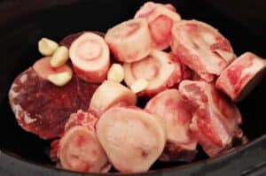 raw bones and garlic in crockpot