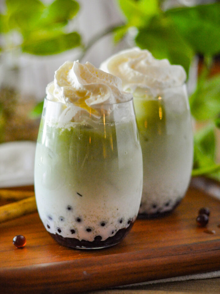 Matcha Bubble Tea on the table with whip cream on top